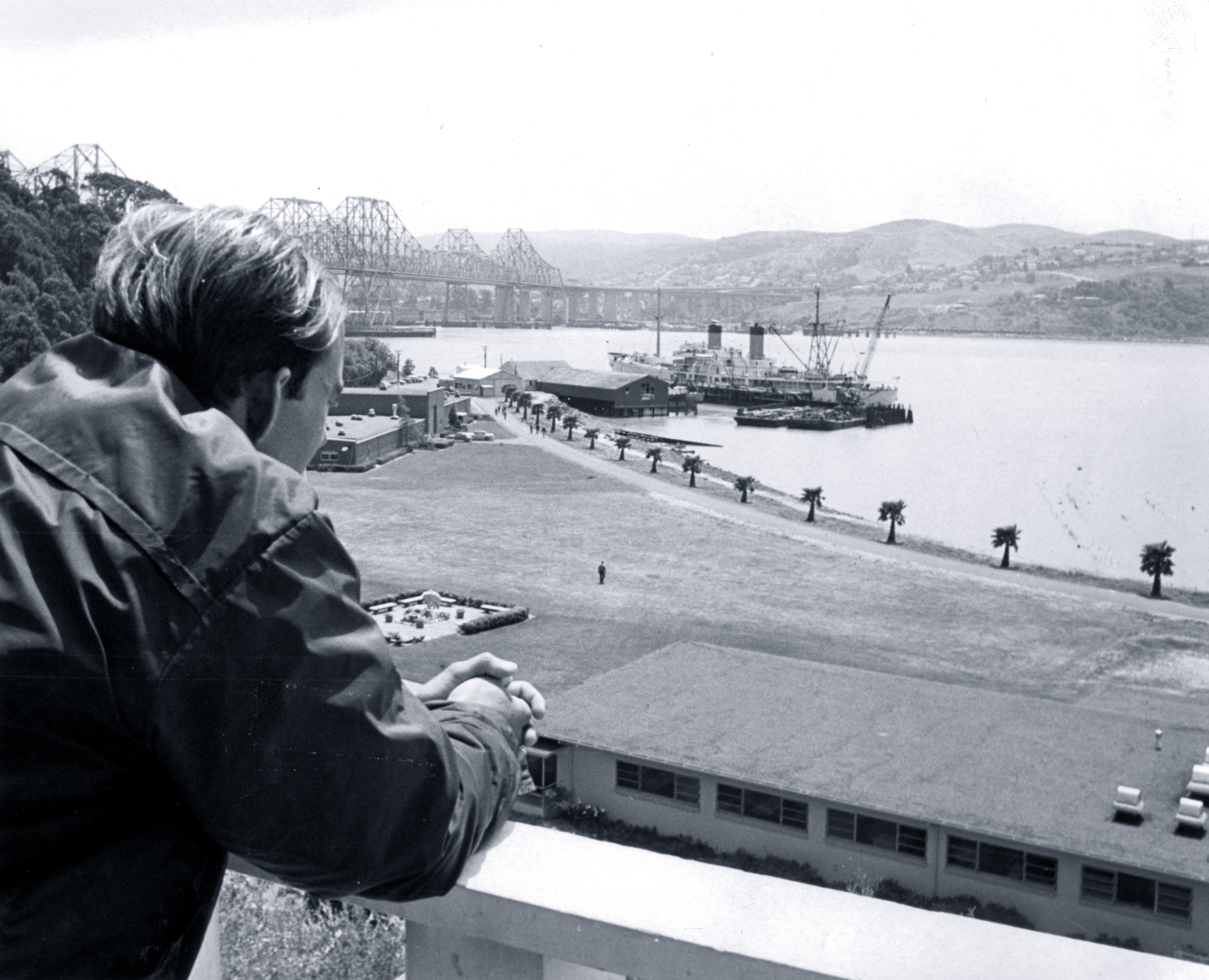 A person looks out at the waterfront at Cal Maritime.
