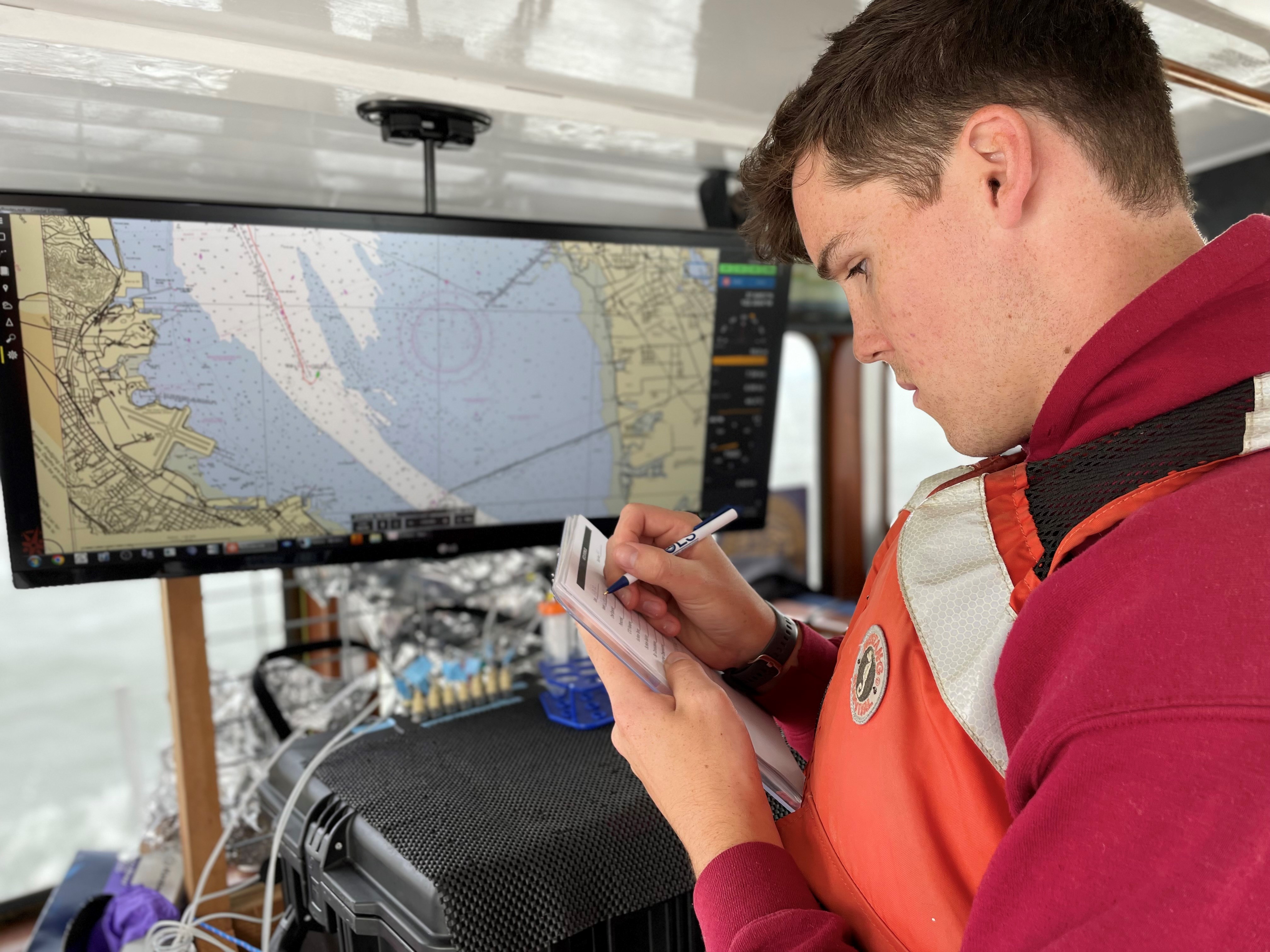 Oceanography cadet Josh Bennett writes notes aboard R/V Questuary