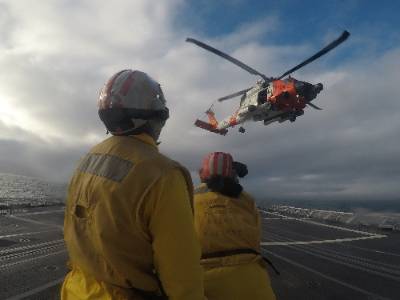 Coast Guard Helo Taking off with two people 