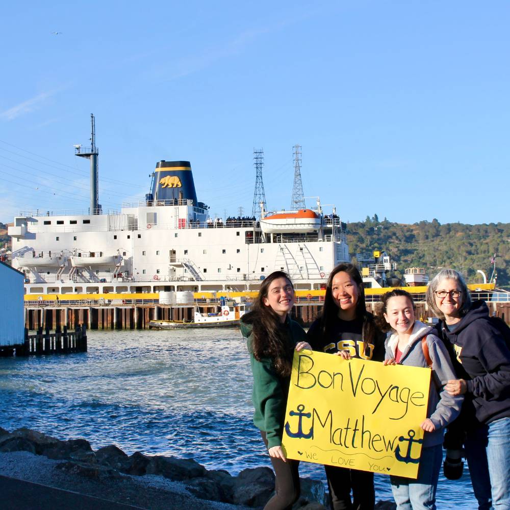 Bon Voyage sign that family holds up in front of TSGB