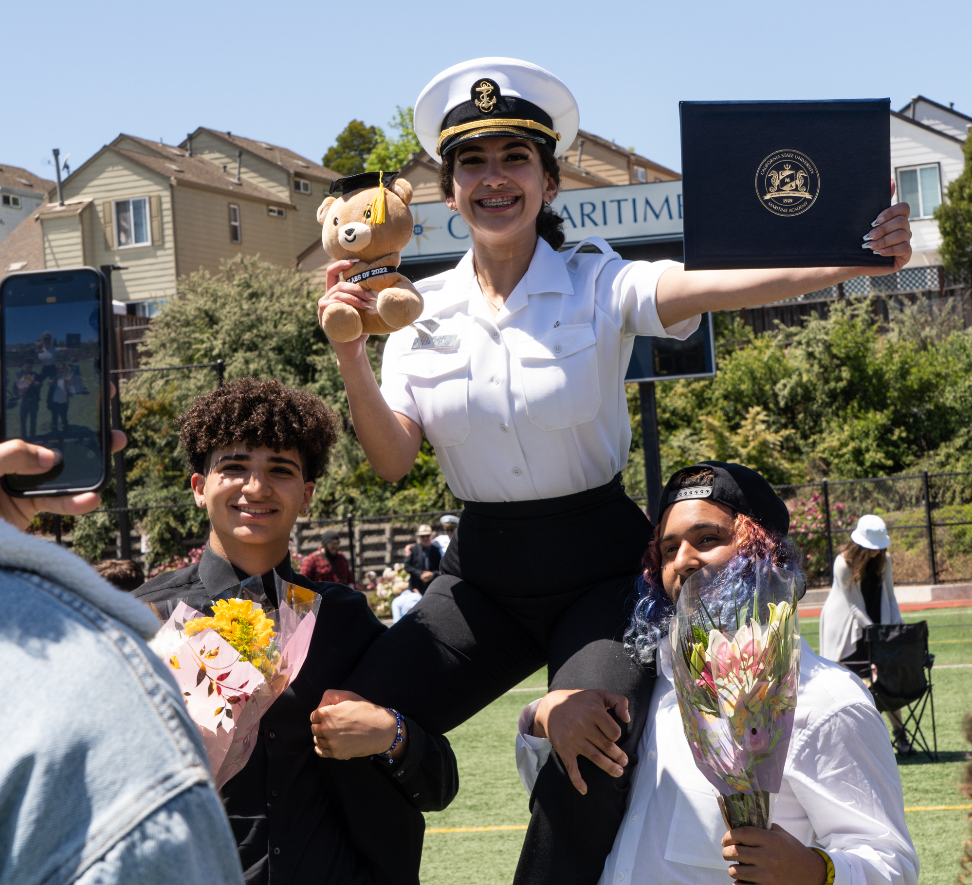 A Cal Maritime graduate poses with family and friends during 2022 Commencement.
