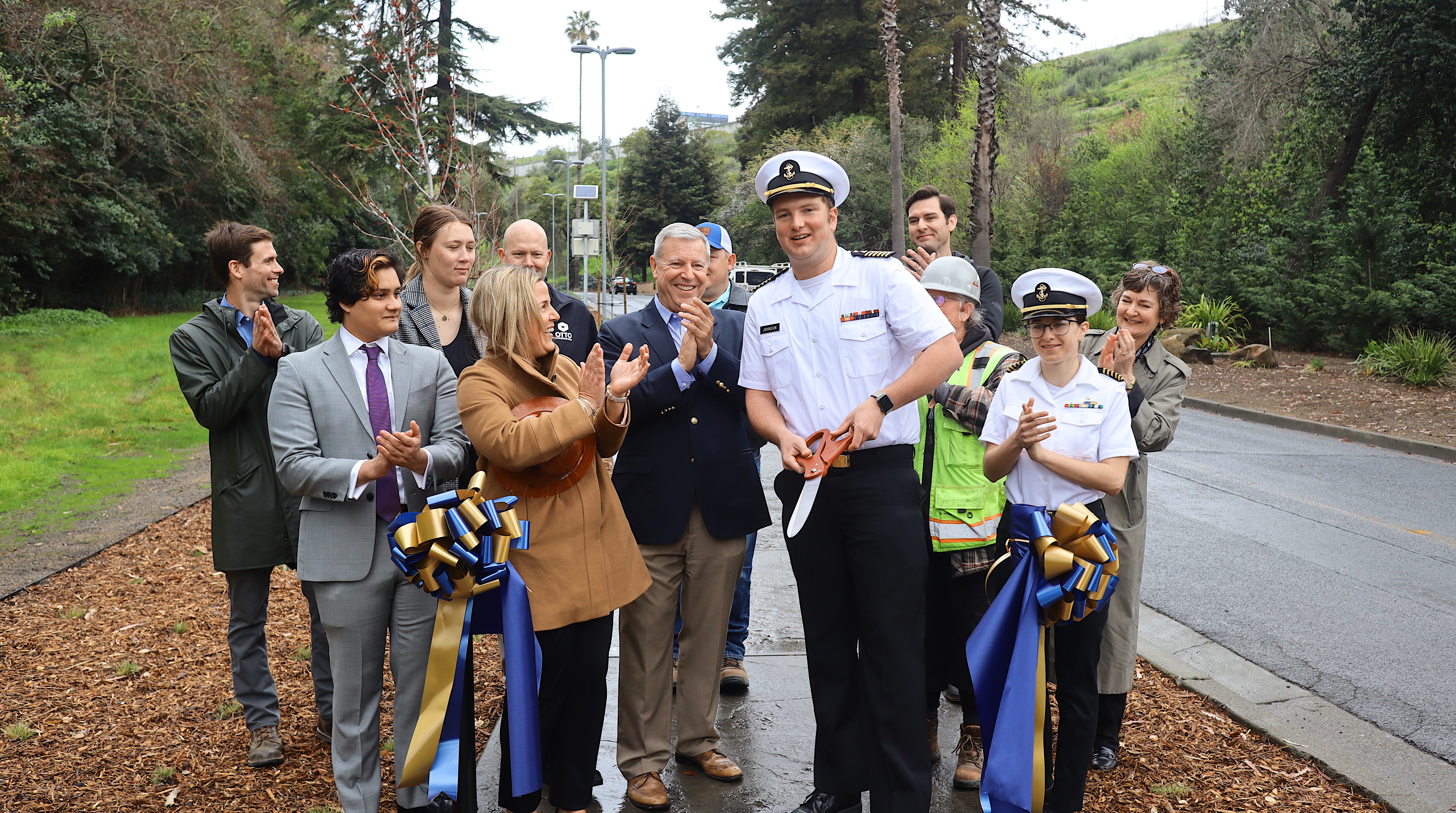 Craig Johnson ‘23, MT mans the scissors as President Cropper, administrators, cadets, and project partners celebrate the completion of Maritime Academy Drive walkway.