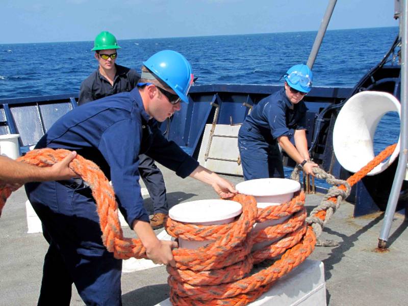 Photo of deck cadets aboard the Training Ship GOLDEN BEAR working lines during mooring training.