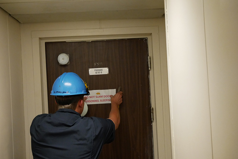 Cadet Sprokkereef affixing door sign