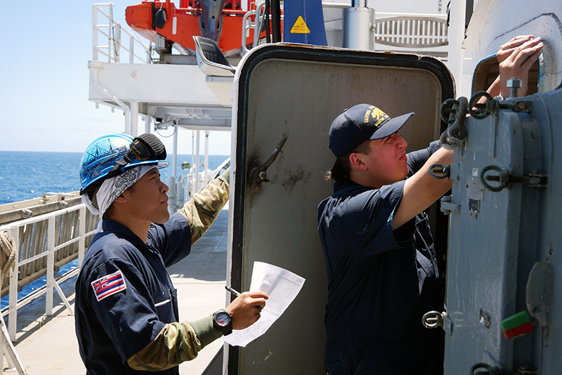 Two cadets inspecting hatches outside