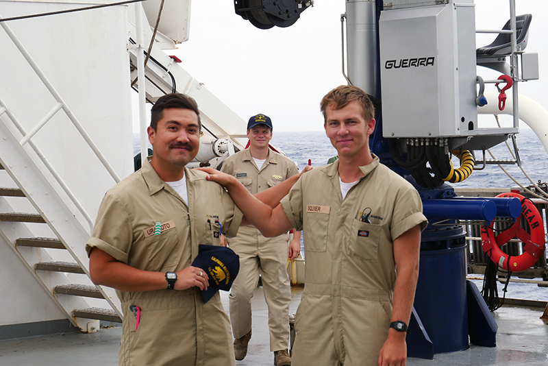 Three cadets smiling on deck