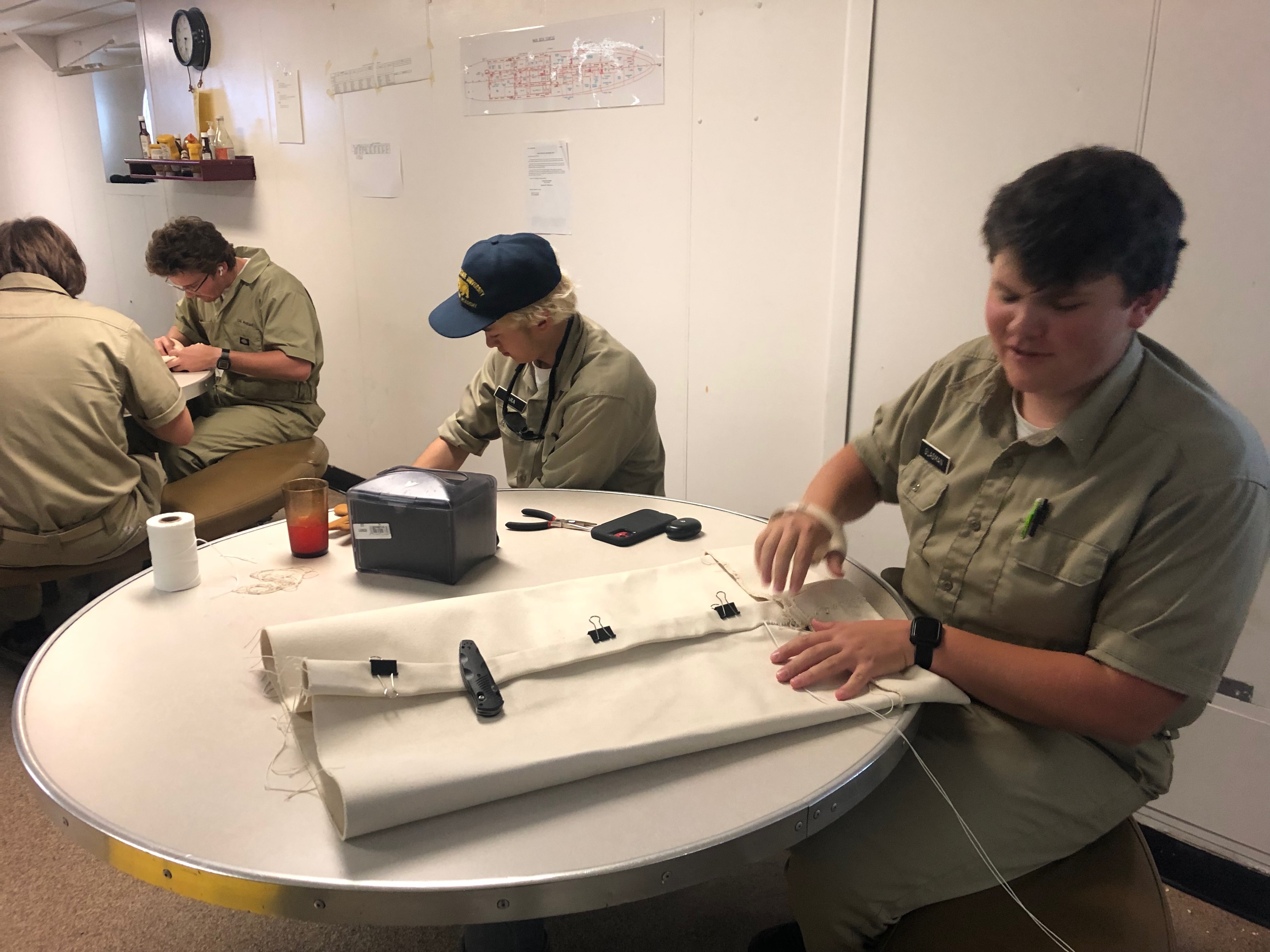 Cadets work on their canvas bags much like sailors from the days of tall ships all the way to World War II, and into the 21st century