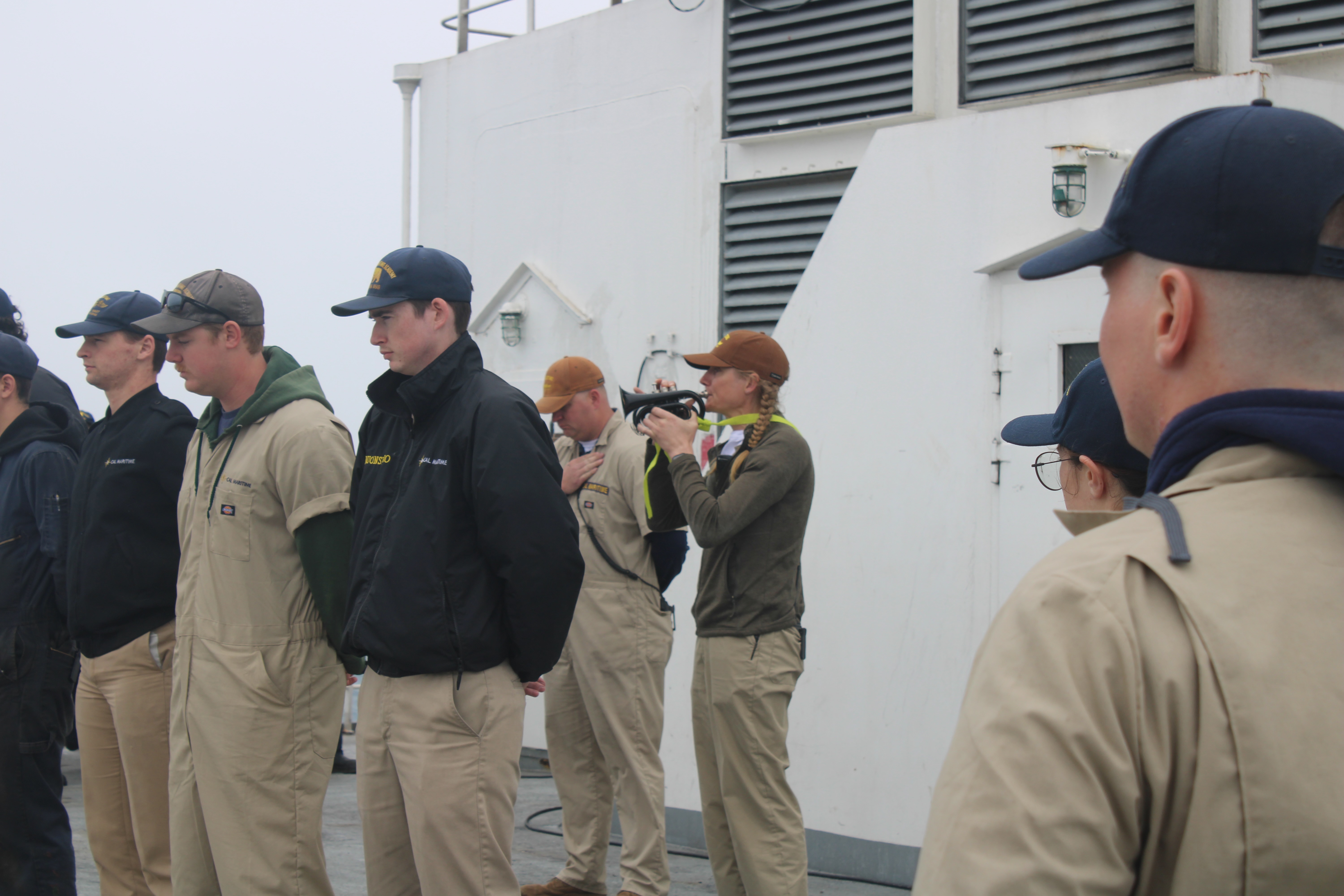 Second Mate Beth Neumyer plays Taps on the trumpet