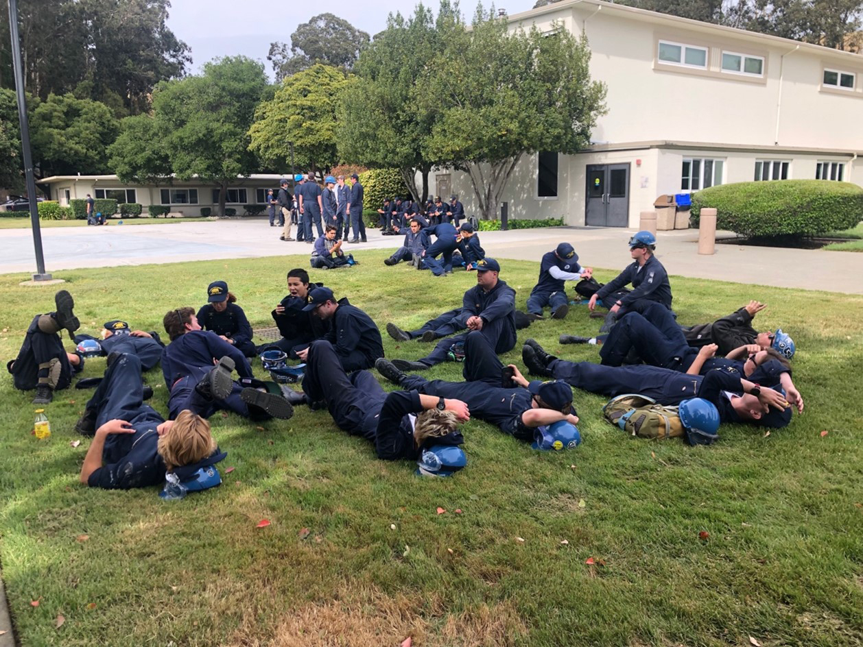 10 Cadets are laying in the grass waiting for afternoon formation after a hot day in the sun