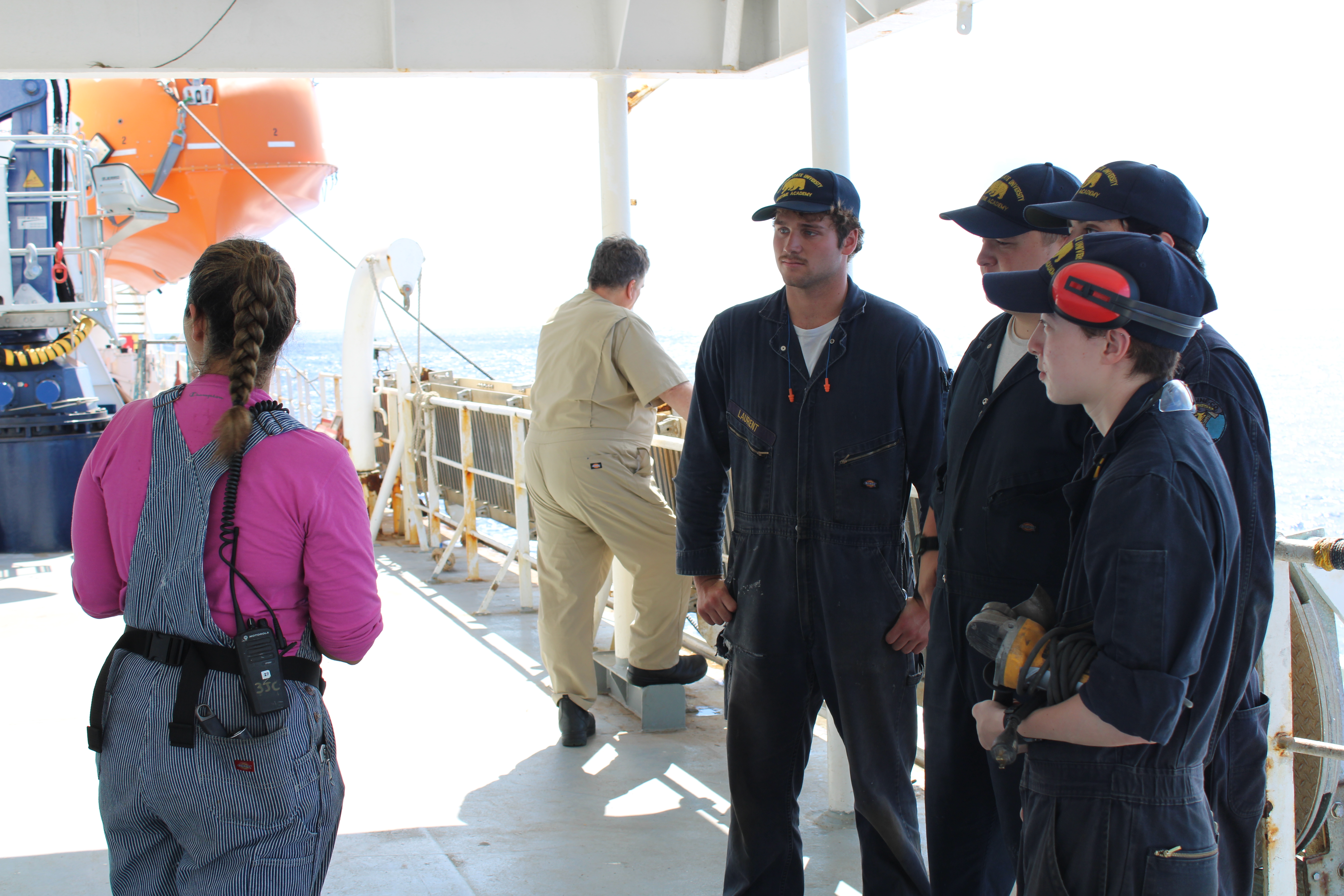 Featured in this photo is the licensed watch engineer (pink shirt), providing engine cadets with updates on the requested support work for the afternoon. 